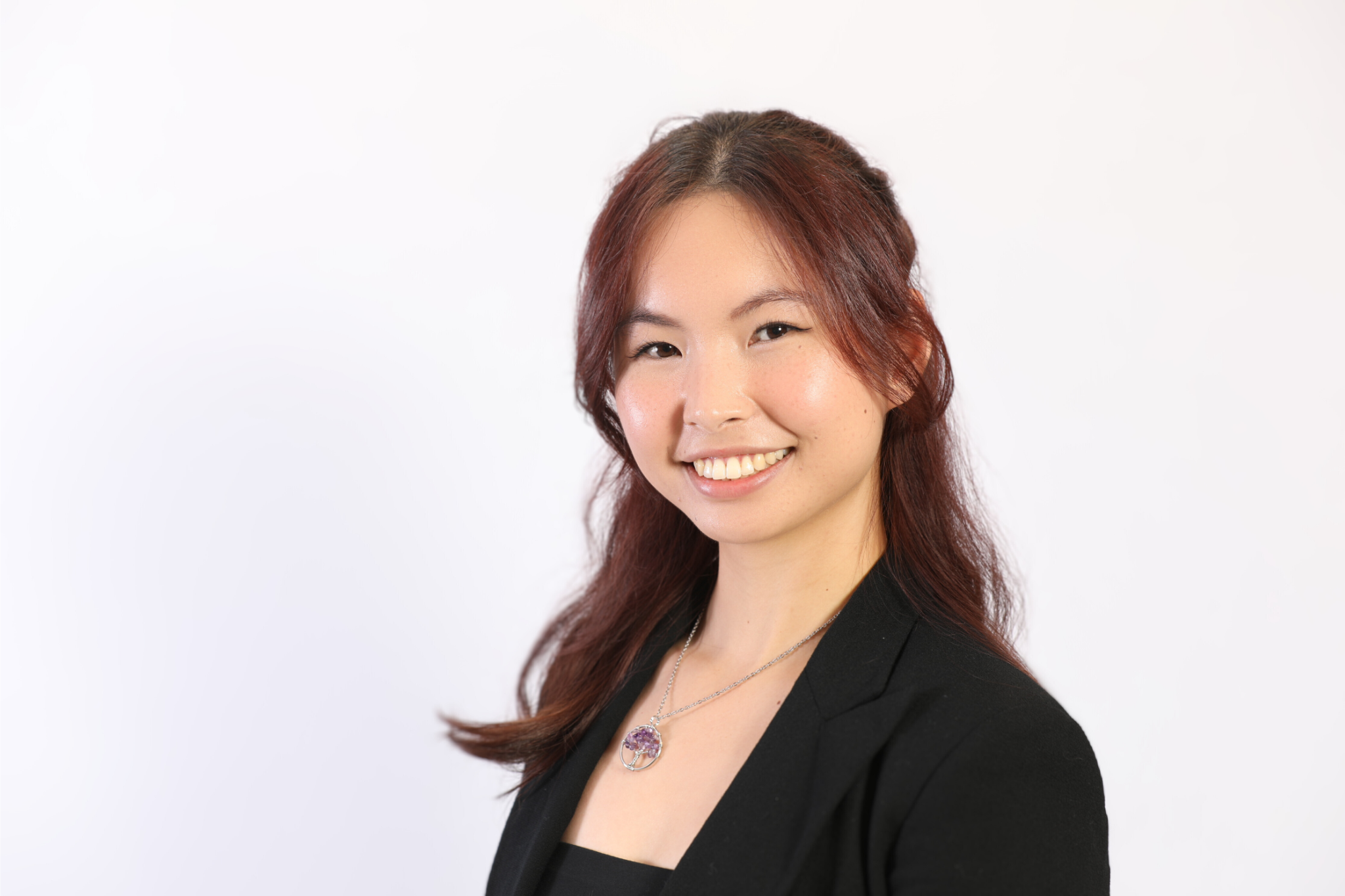 Sunny Yimeng Dong, a 24 year old Chinese Canadian girl with cherry red hair, black blazer, and a Tree of Life necklace